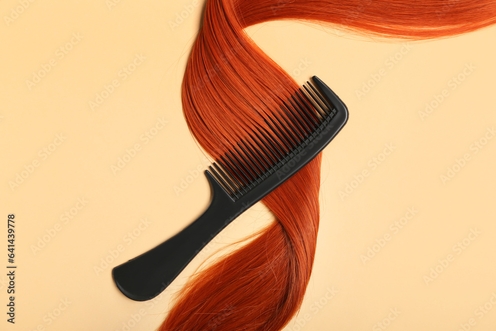 Ginger hair strand with comb on color background, closeup