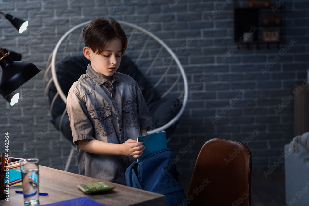 Little boy preparing for school at home in evening