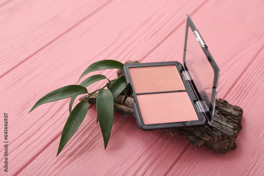 Blusher, tree bark and plant leaf on color wooden background