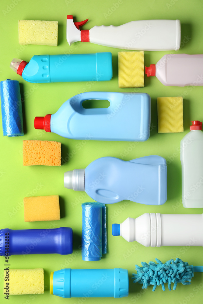 Many different cleaning supplies on green background