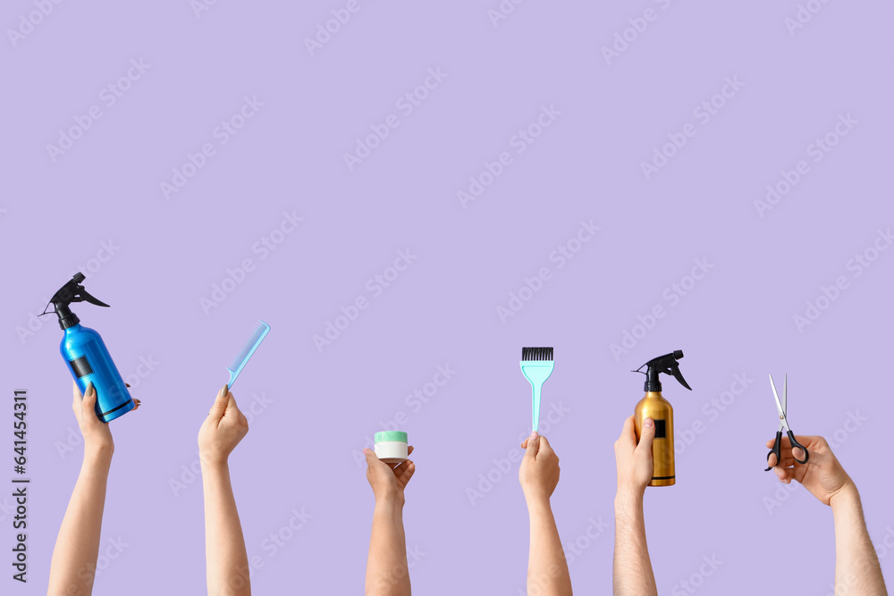 Many hands with different hairdressing supplies on lilac background