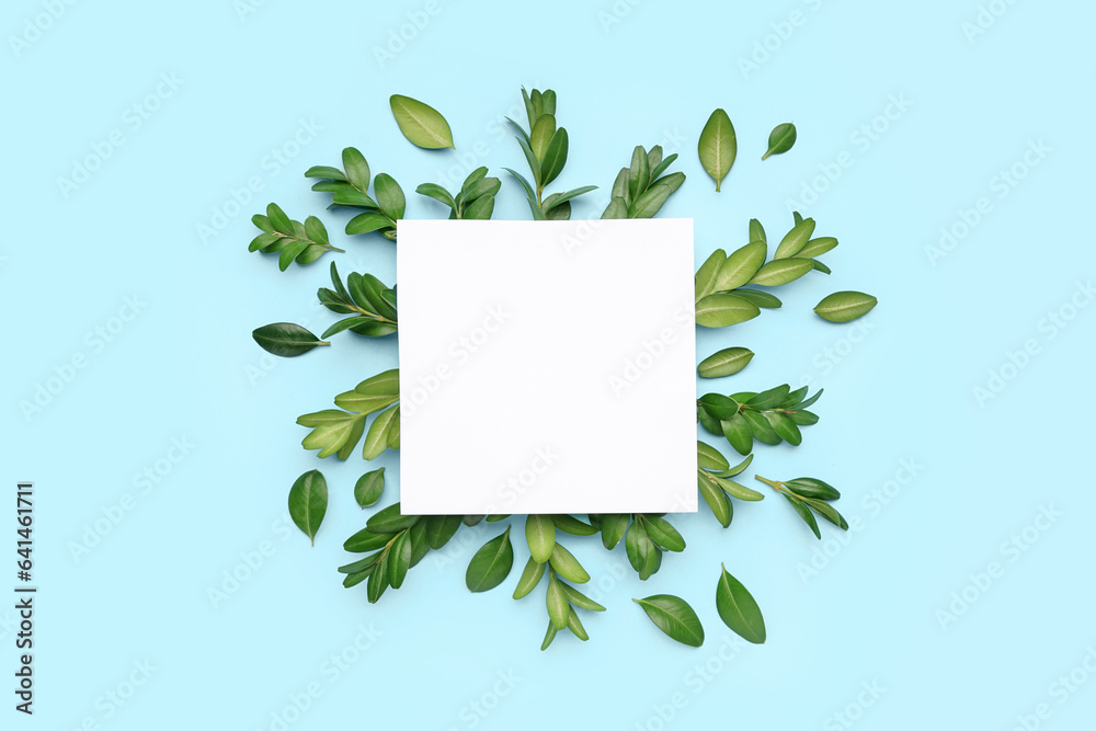 Blank card with green leaves on blue background