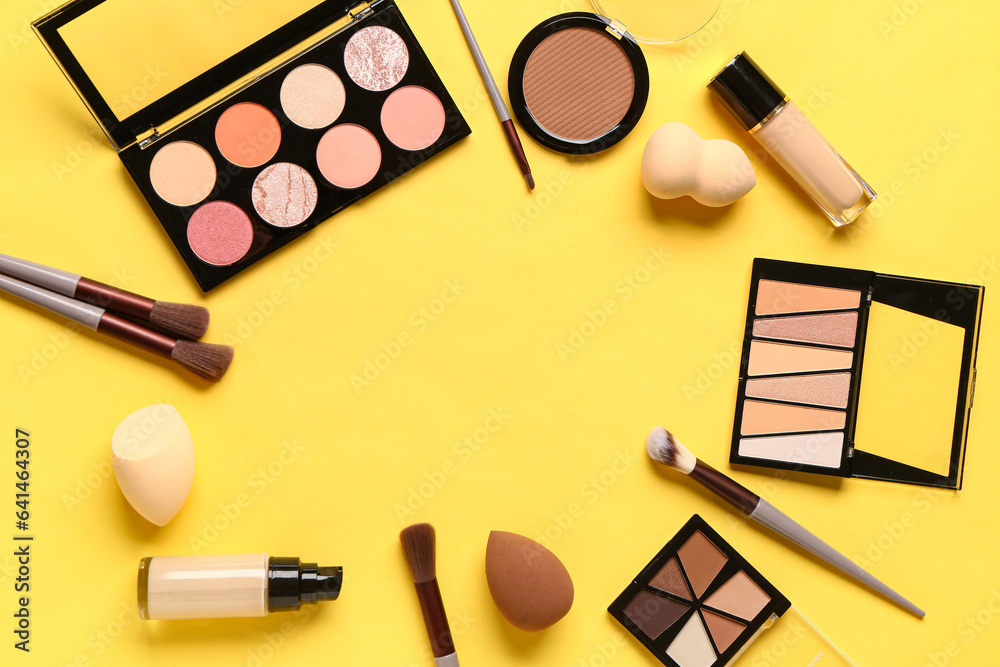 Frame made of makeup accessories and cosmetics on yellow background