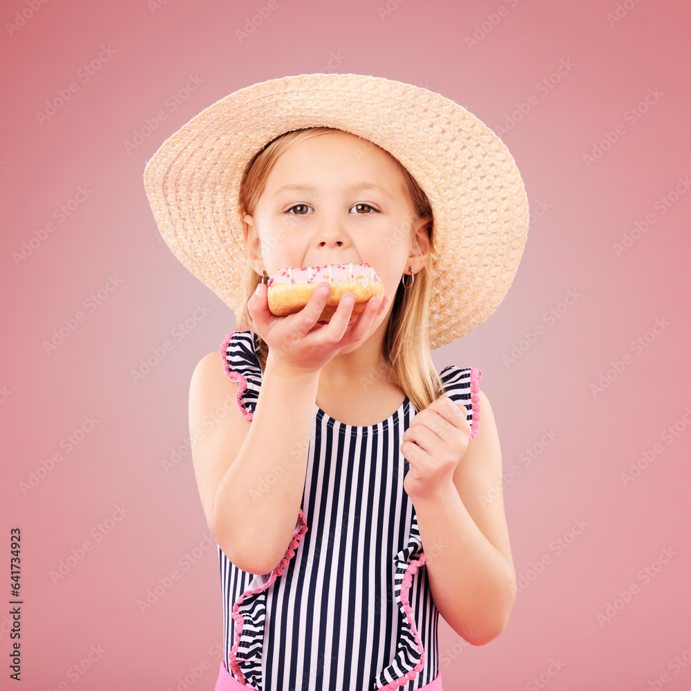 Girl kid, eating a donut and dessert, sweets and summer with hat and bathing suit isolated on pink b