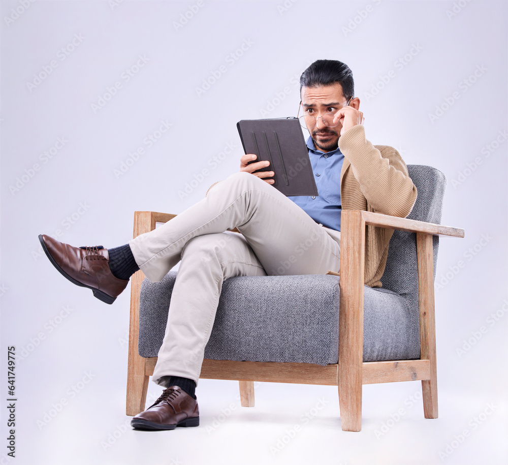 Tablet, concern and a man psychologist in a chair on a white background in studio to listen for diag