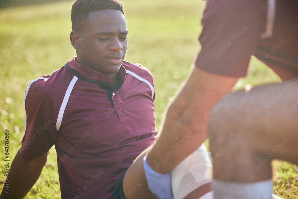 First aid, sport injury and black man with soccer accident, fitness and massage on a field. Training