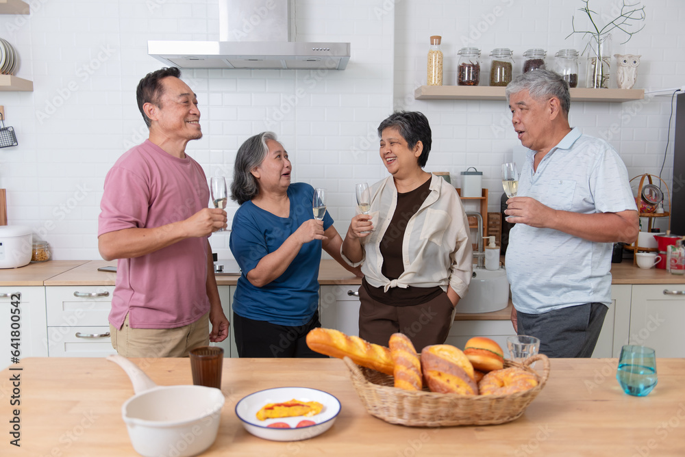 Happy Asian senior dining together drinking wine to celebrate