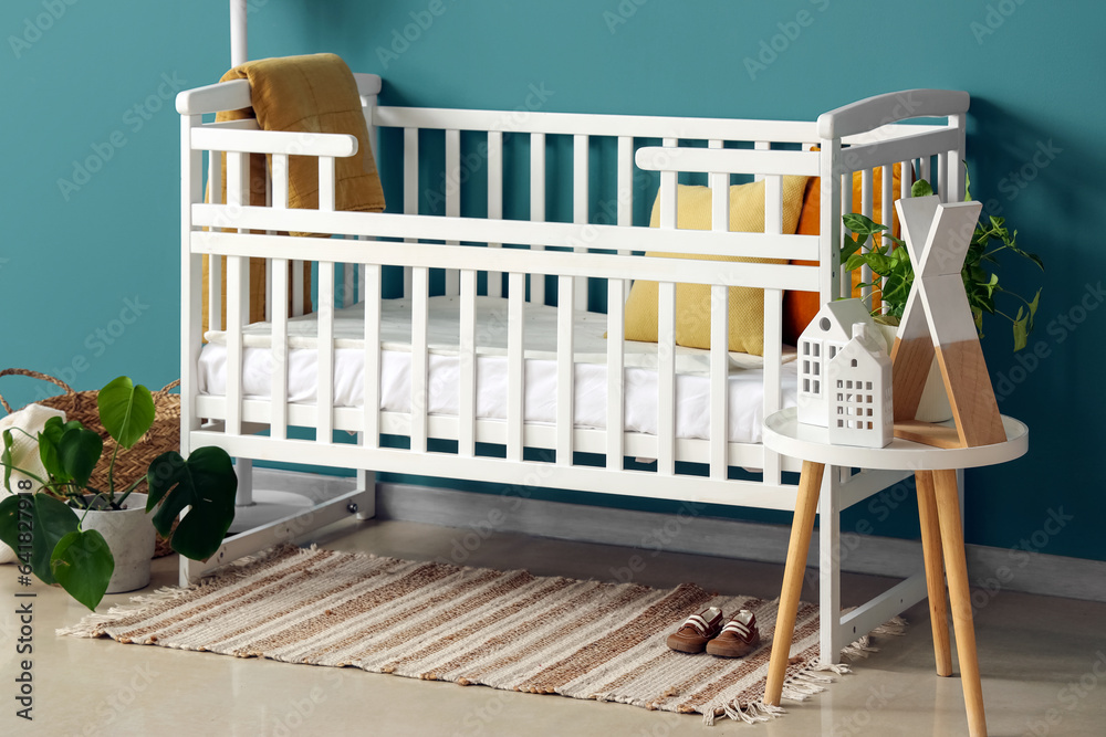 Interior of bedroom with baby crib and table