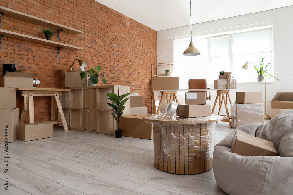 Interior of stylish office with cardboard boxes on moving day