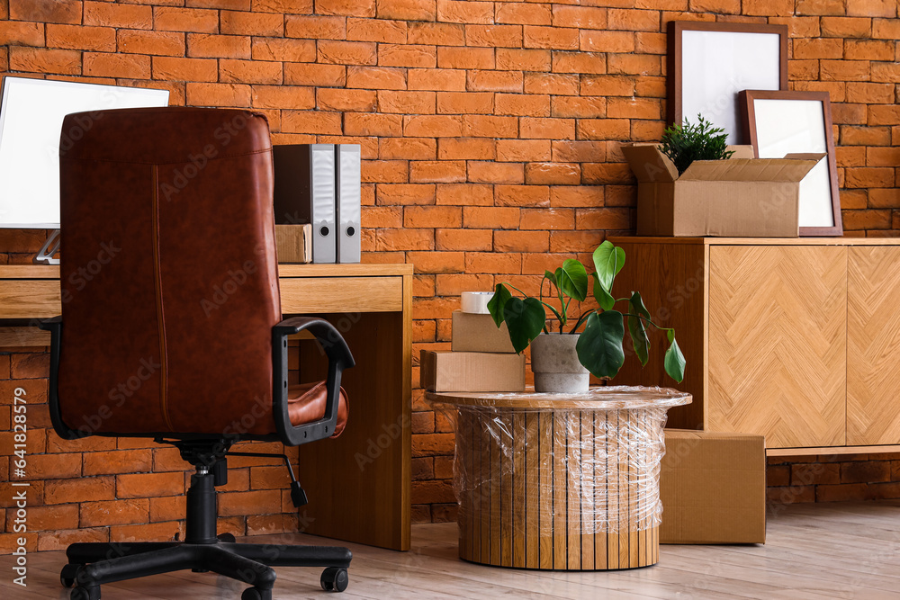 Interior of stylish office with cardboard boxes on moving day