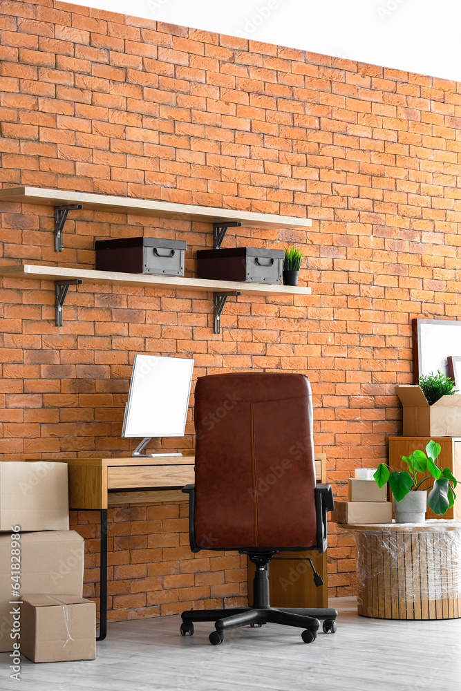 Interior of stylish office with cardboard boxes on moving day