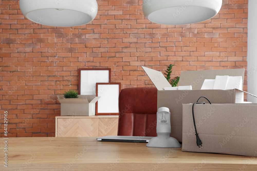 Interior of stylish office with cardboard boxes on moving day