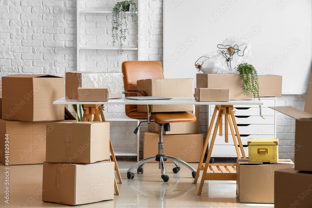 Workplace with cardboard boxes in office on moving day