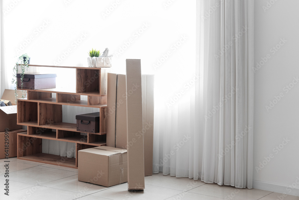 Shelving unit with cardboard boxes in office on moving day