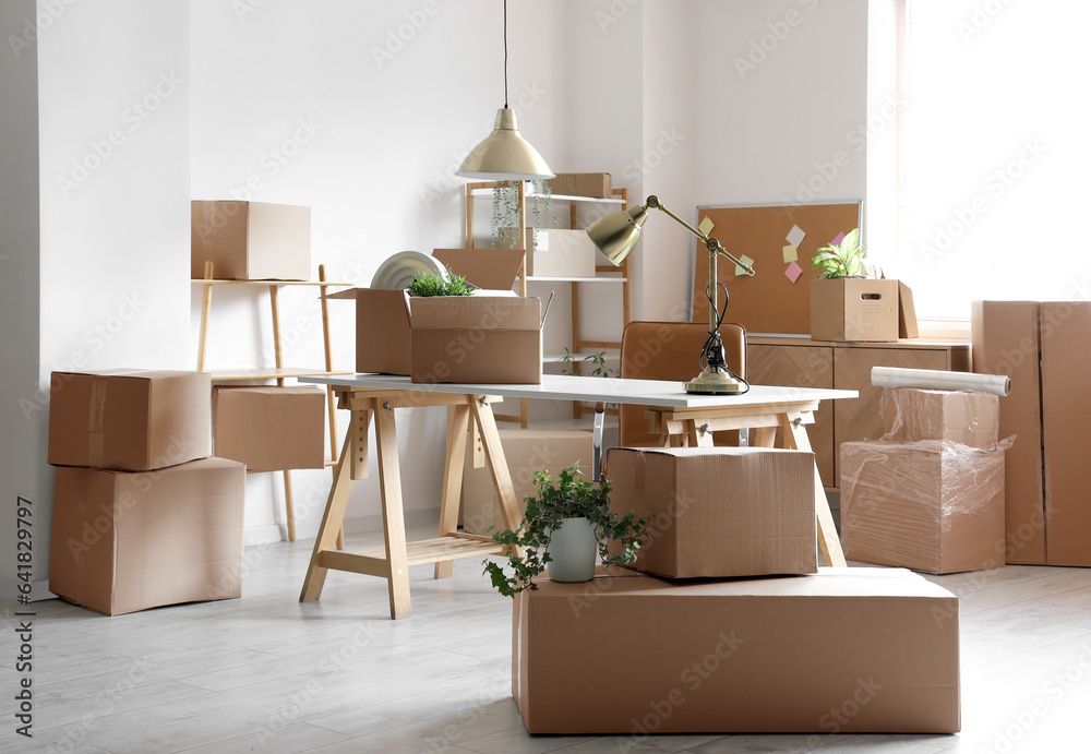 Modern workplace with cardboard boxes in office on moving day