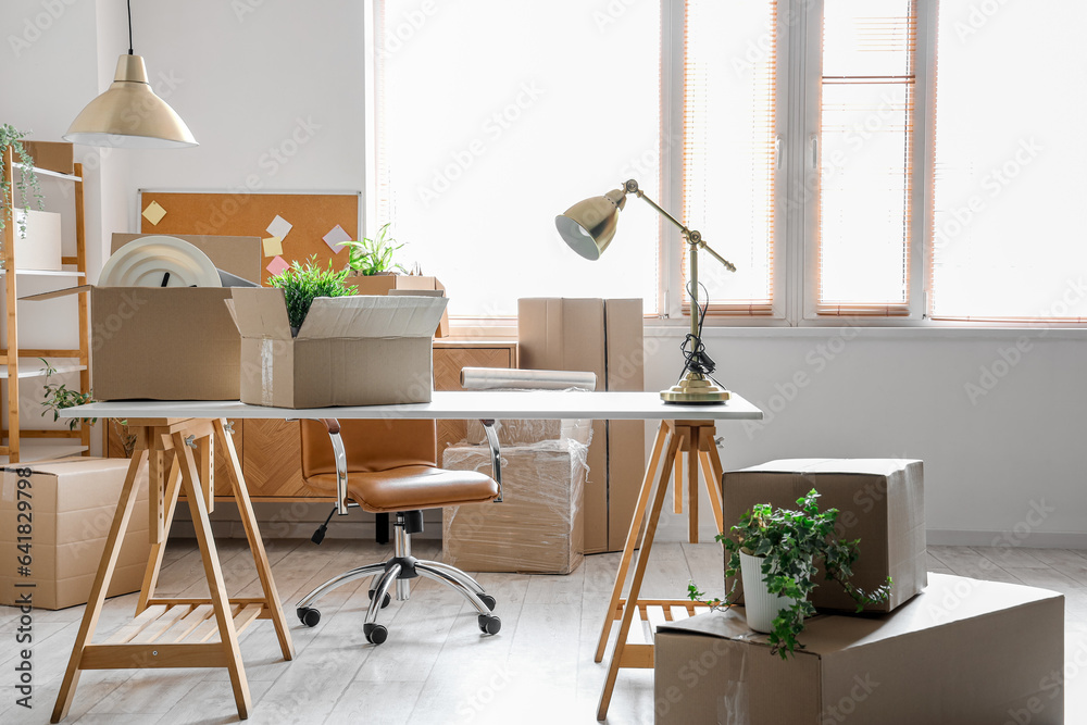 Modern workplace with cardboard boxes in office on moving day