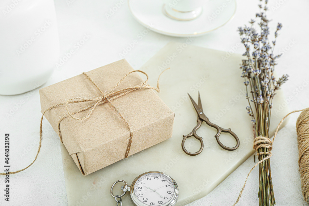 Tied box with scissors and dried lavender on white table