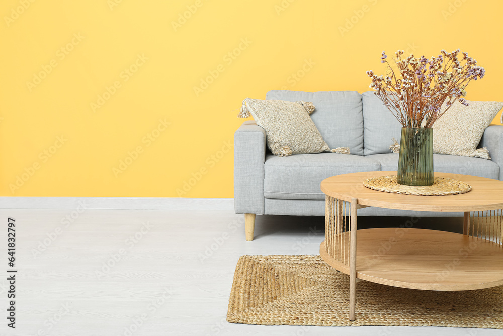 Vase of dried flowers on coffee table near couch