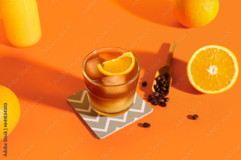 Glass of tasty orange espresso on color background