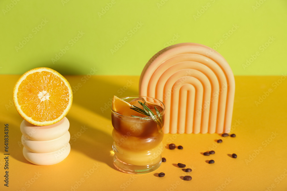 Glass of tasty orange espresso on color background