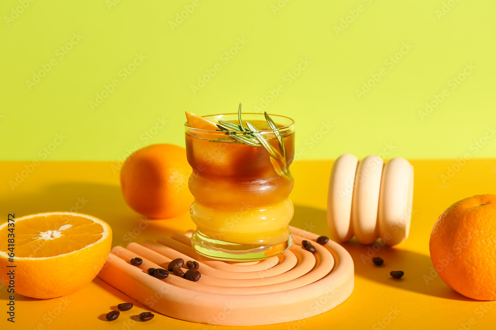 Glass of tasty orange espresso on color background