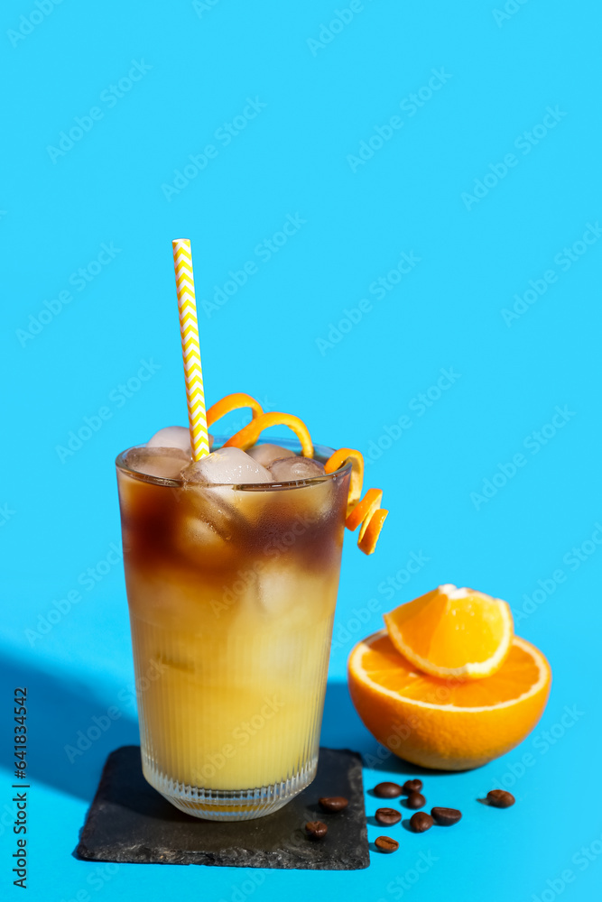 Glass of tasty orange espresso on blue background