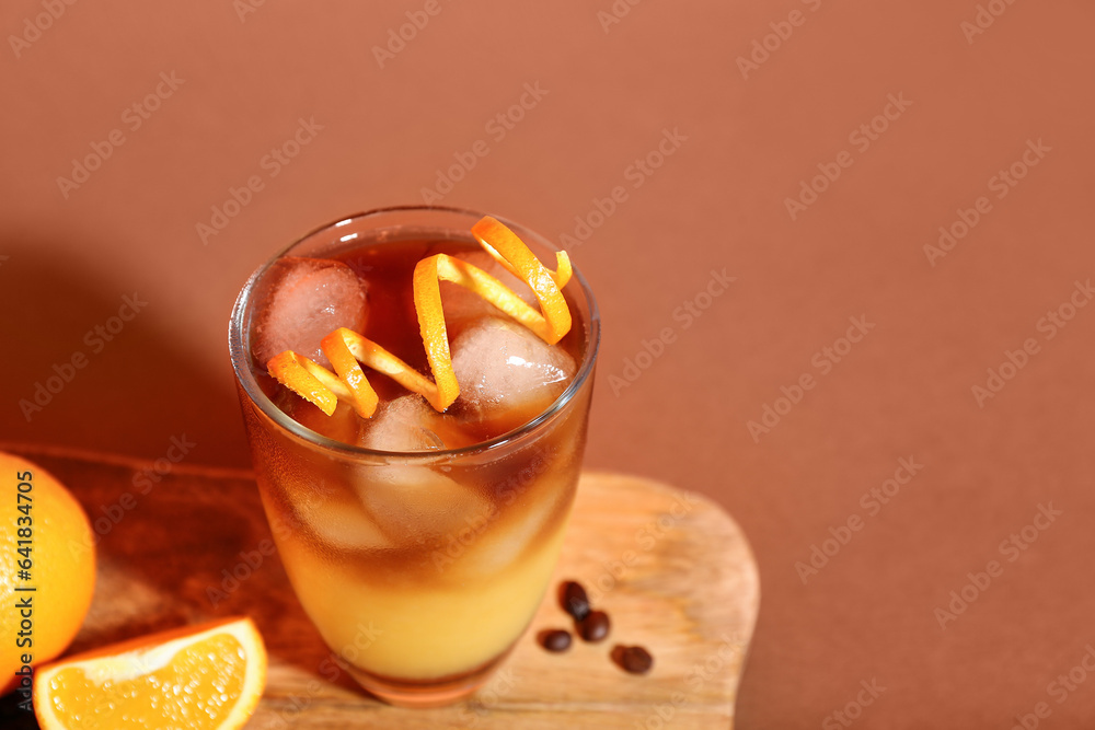 Glass of tasty orange espresso on color background