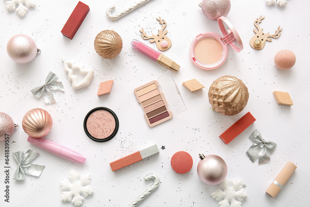 Composition with decorative cosmetics and Christmas decor on white background