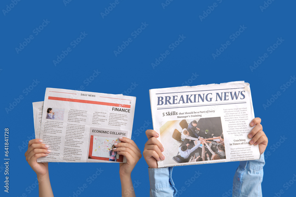 Female hands with newspapers on blue background