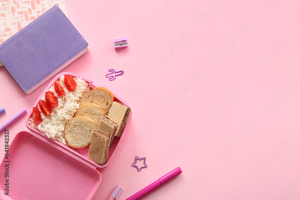 Lunchbox with delicious food and different stationery on pink background