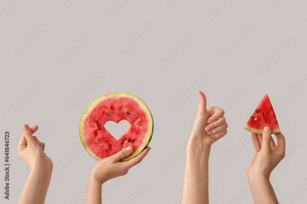 Women holding piece of ripe watermelon and slice with heart on white background