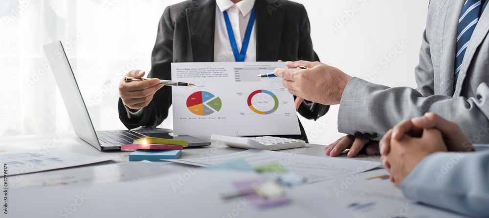 Business People Meeting using laptop computer,calculator,notebook,stock market chart paper for analy