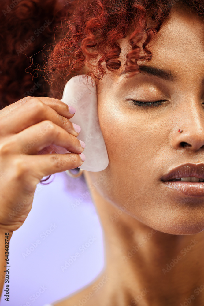 Skincare, face and woman with gua sha in studio for facelift, wellness or anti aging on purple backg