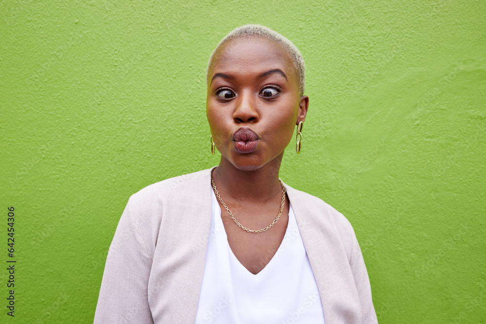 Happy, silly and young black woman by a green wall with trendy, classy and elegant jewelry and outfi