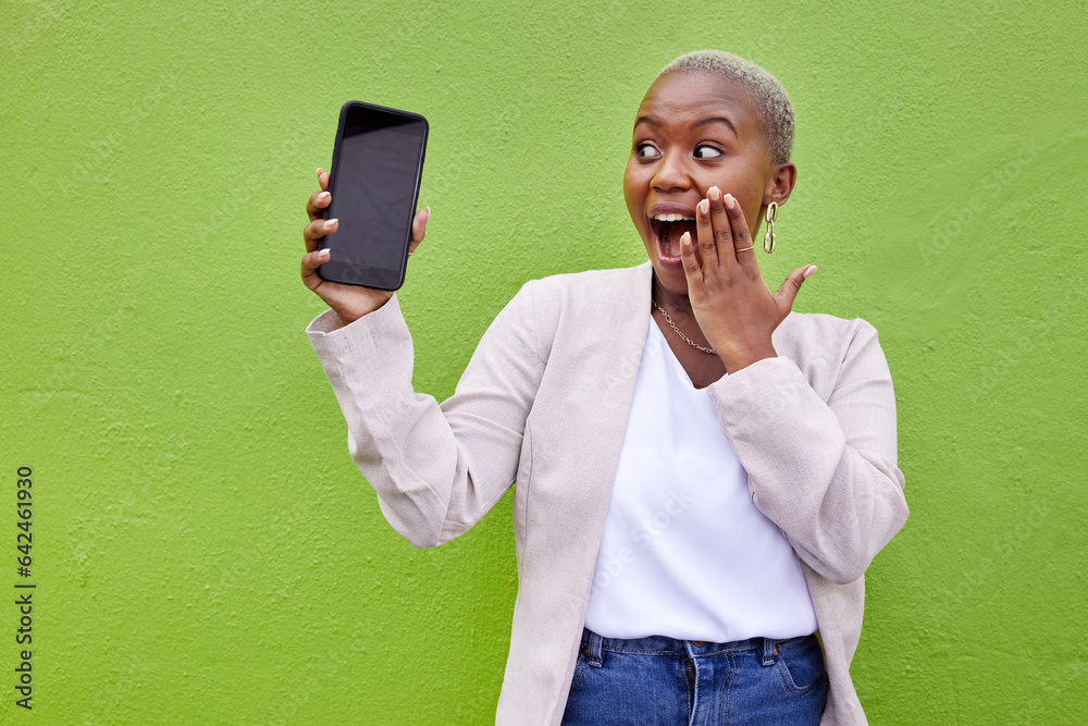 Woman, surprise and phone screen with mockup by a wall or green background with wow advertising. Sho