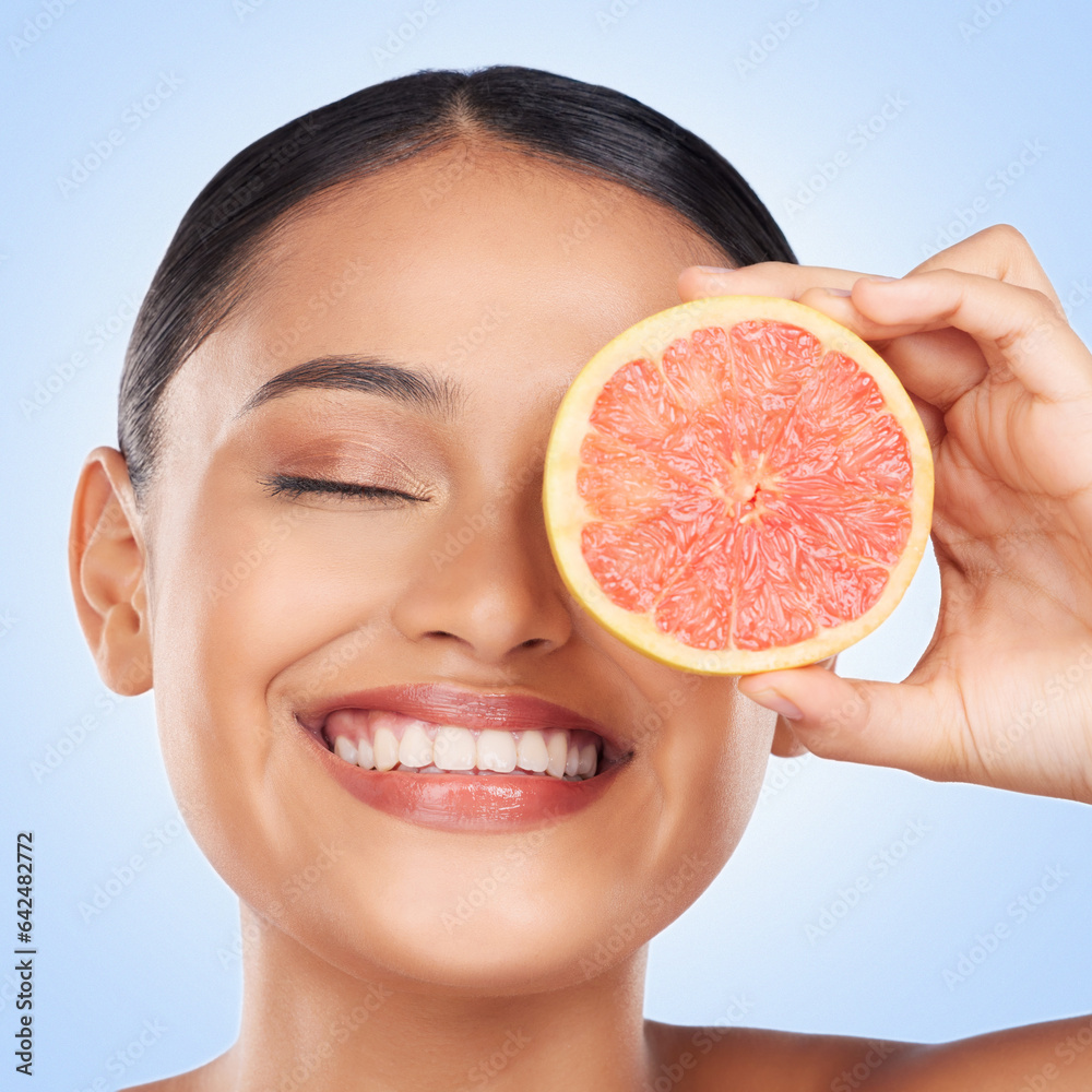 Face, skincare and grapefruit with a natural woman in studio on a blue background for health or well