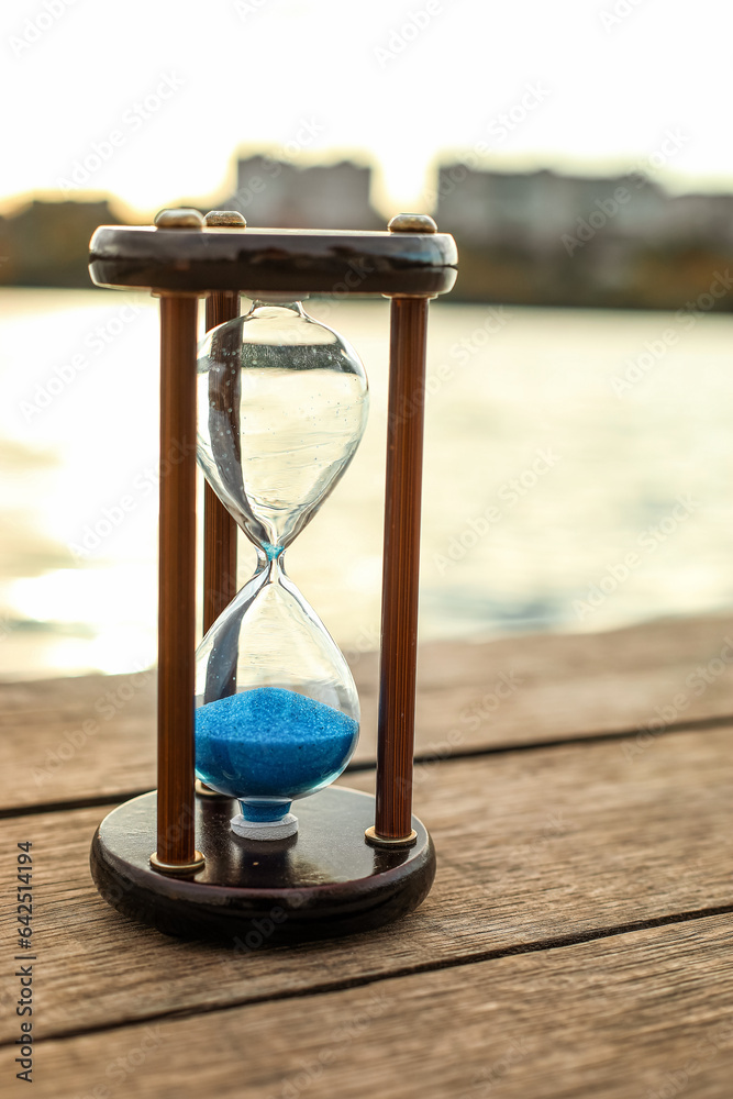 Hourglass on bridge near river, closeup