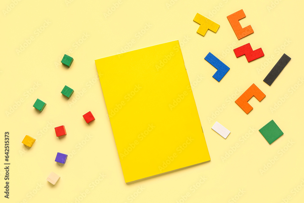 Notebook with cubes and blocks on yellow background. Logic concept