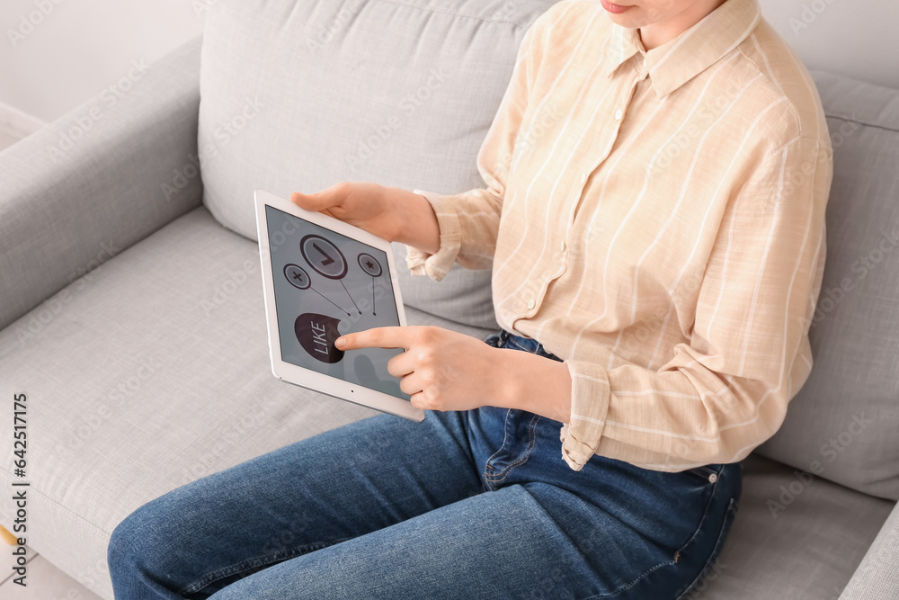 Woman with tablet computer taking experience survey on sofa at home, closeup