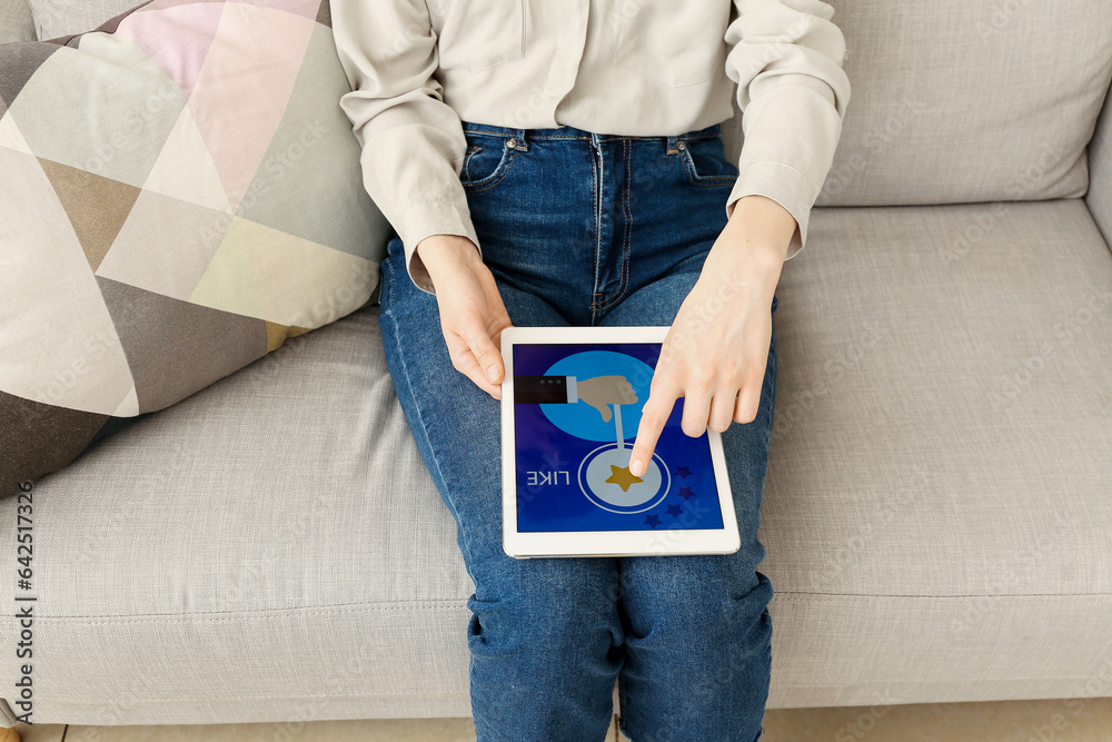 Woman with tablet computer taking experience survey on sofa at home, closeup