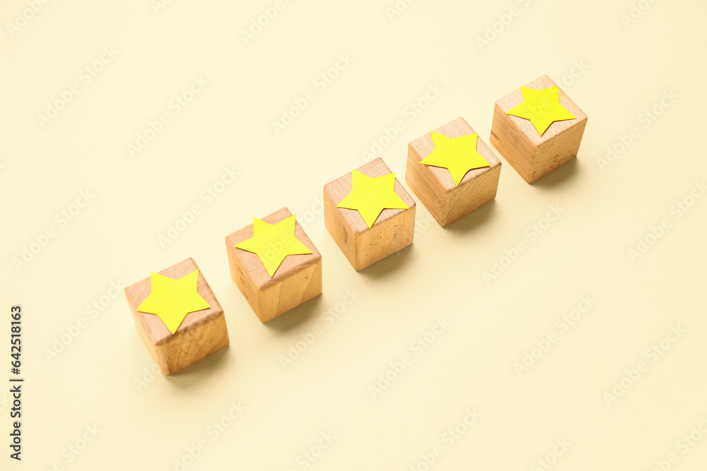 Five cubes with stars on beige background. Customer experience concept