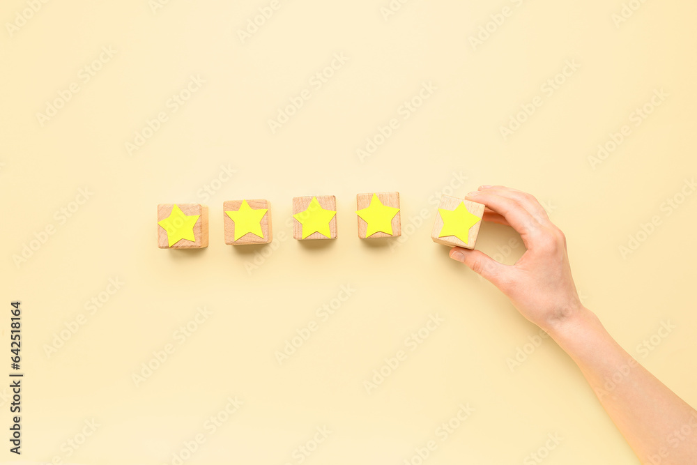 Woman with cubes and five stars on beige background. Customer experience concept