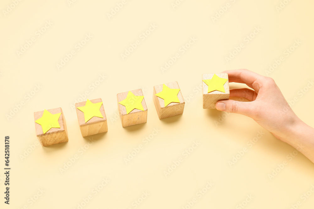 Woman with cubes and five stars on beige background. Customer experience concept