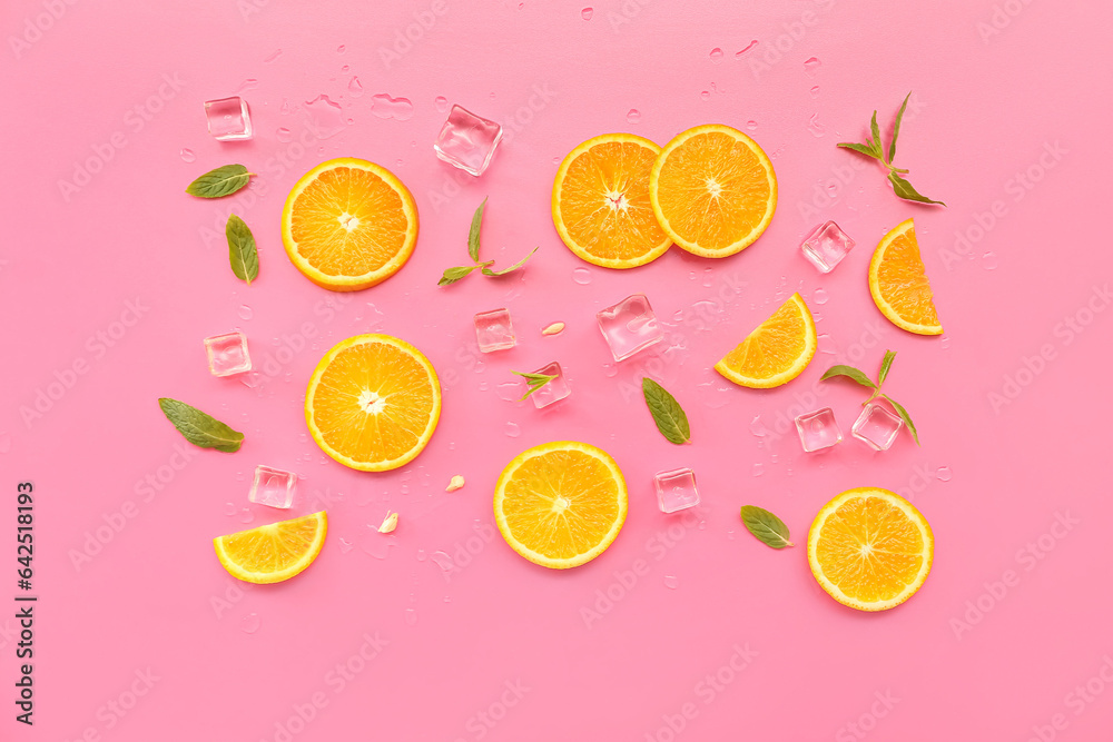 Orange slices with water drops, mint and ice cubes on pink background