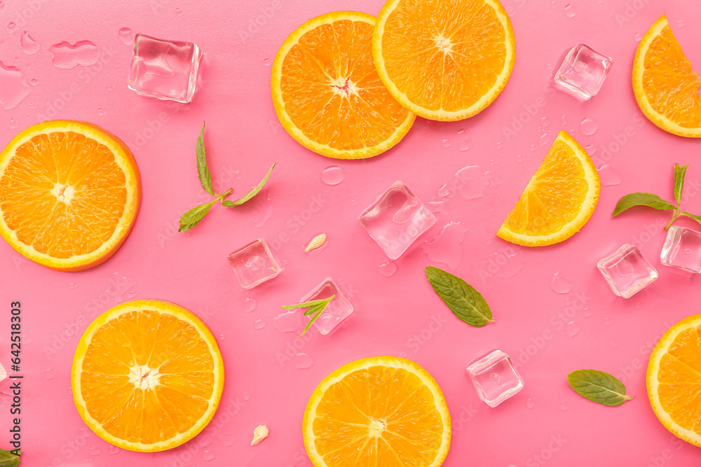 Orange slices with water drops, mint and ice cubes on pink background