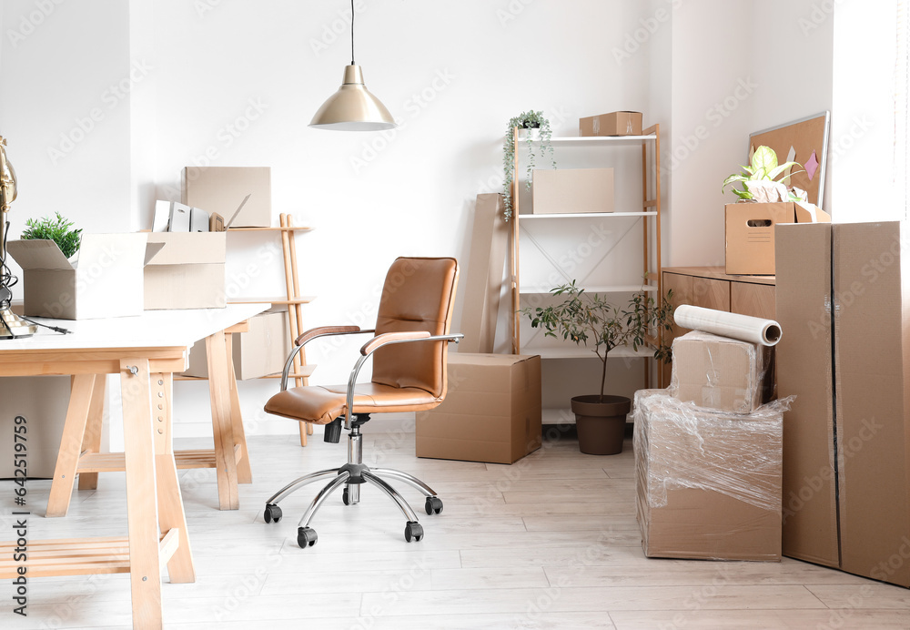 Modern workplace with cardboard boxes in office on moving day