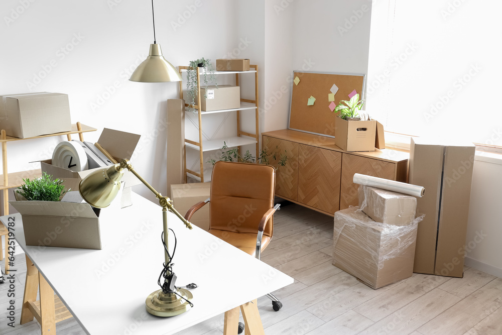 Modern workplace with cardboard boxes in office on moving day