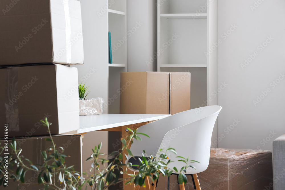 Modern workplace with cardboard boxes in office on moving day