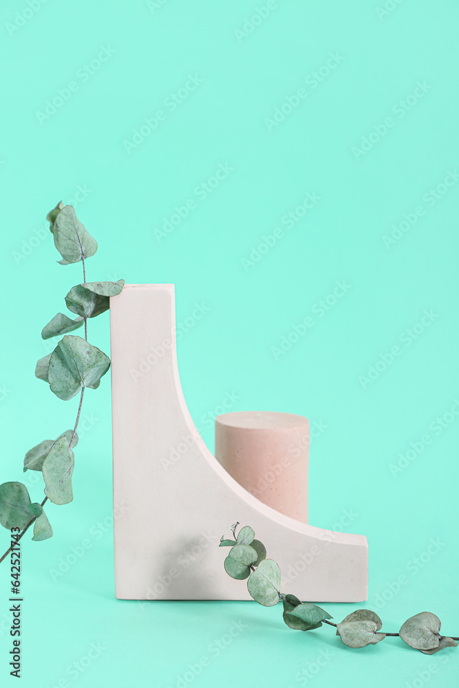 Decorative plaster podiums with eucalyptus on turquoise background