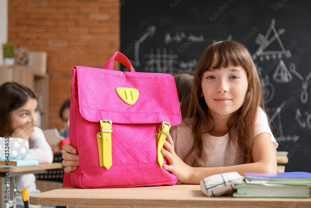 Little girl with backpack in classroom